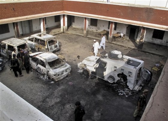 Pakistani police officers examine damaged vehicles, a day after Taliban militants attacked a police station, Sunday, June 26, 2011 in Kolachi near Dera Ismail Khan, Pakistan. The Pakistani Taliban say they used a female suicide bomber for the first time in the attack. 